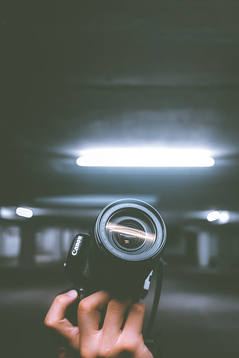 person holding black Canon DSLR camera inside indoor vehicle garage, HD phone wallpaper