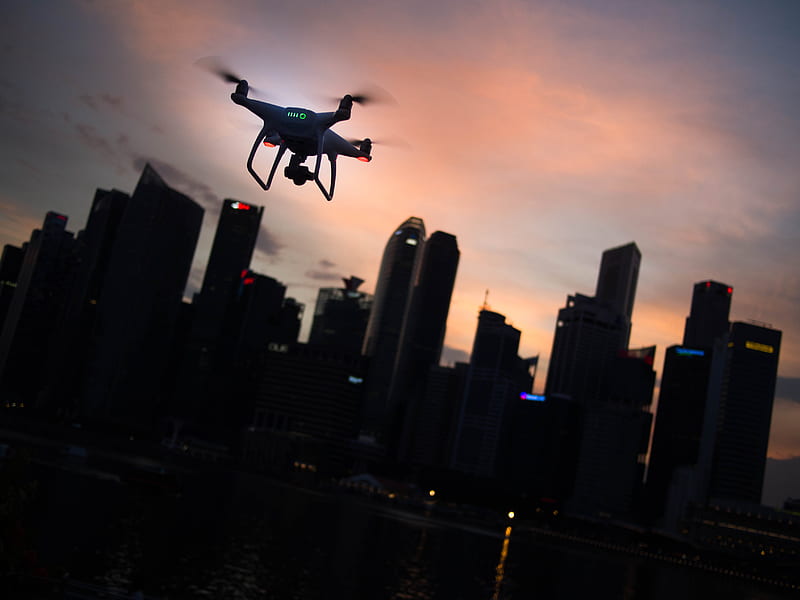 silhouette of quadcopter drone hovering near the city, HD wallpaper