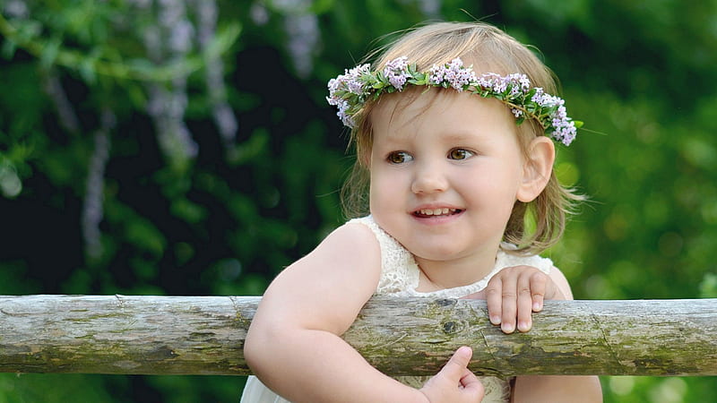 Smiling Cute Baby With White Dress And Flower Crown On Head Is Standing And Holding Wood In Shallow Background Of Green Trees Cute, HD wallpaper