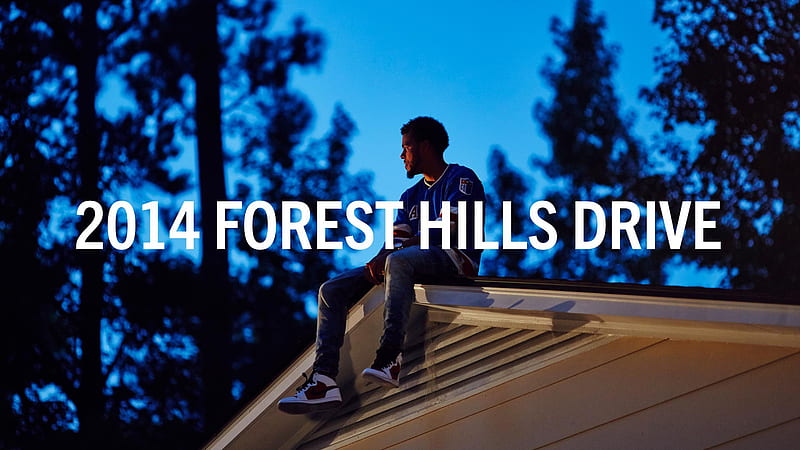 J Cole Is Sitting On Roof Top Wearing Blue T-shirt In Blue Trees Background Music, HD wallpaper