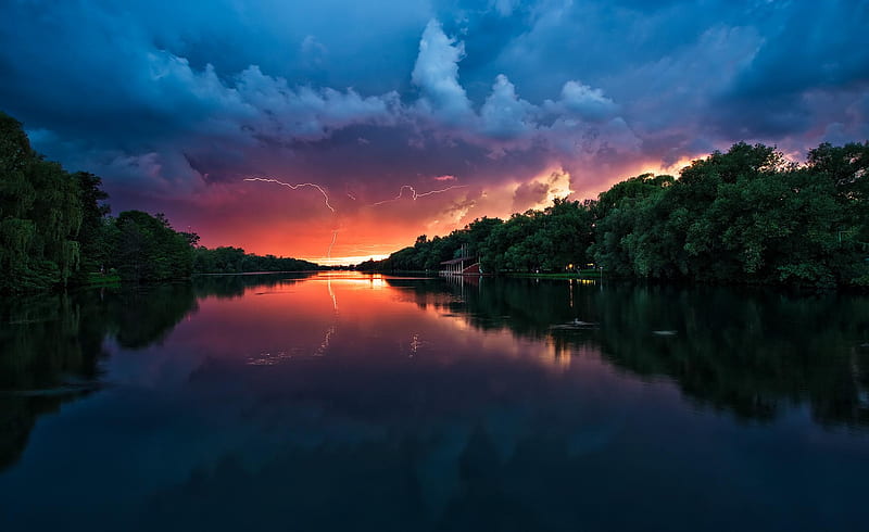 Before the Storm Begins, cloudy, sun, orange, gray, yellow, sunset, clouds, green, river, reflection, pink, blue, spring, sky, storm, trees, lake, water, lightning, plants, summer, sunshine, HD wallpaper