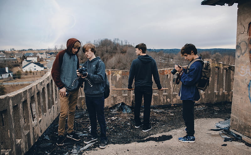 four man wearing blue jackets standing beside house looking at their cameras during daytime, HD wallpaper