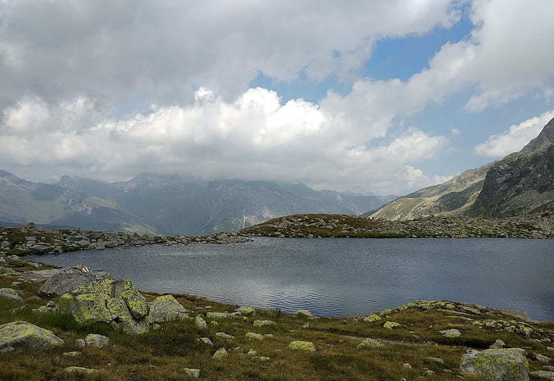 Green and white mountains near body of water under white clouds and ...