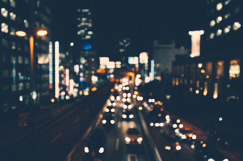 A blurry shot of a city street lit up by buildings and cars at night, HD wallpaper