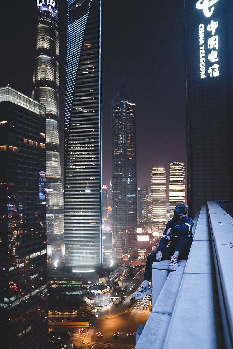 man sitting on building gutter during nighttime, HD phone wallpaper