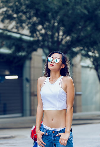 Woman wearing black V-neck sleeveless top and distressed blue