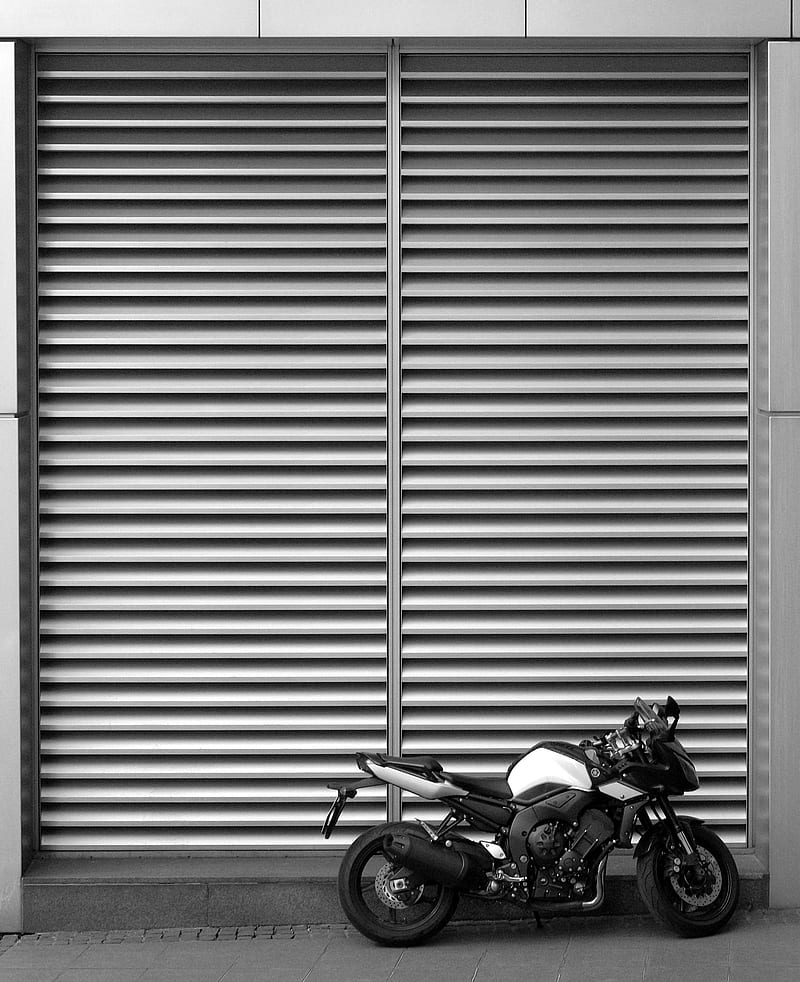backbone motorcycle parked beside roll-up door, HD phone wallpaper