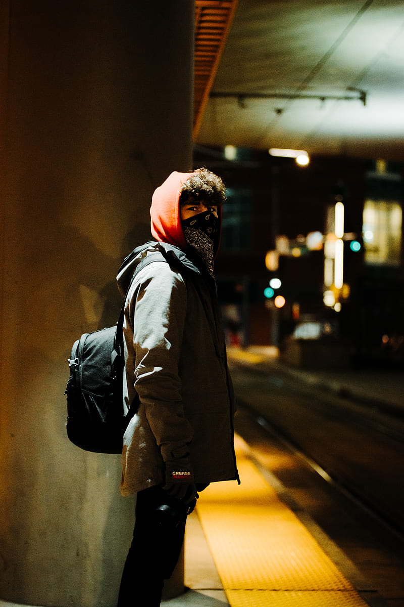 man in brown jacket standing in the middle of the street during night time, HD phone wallpaper