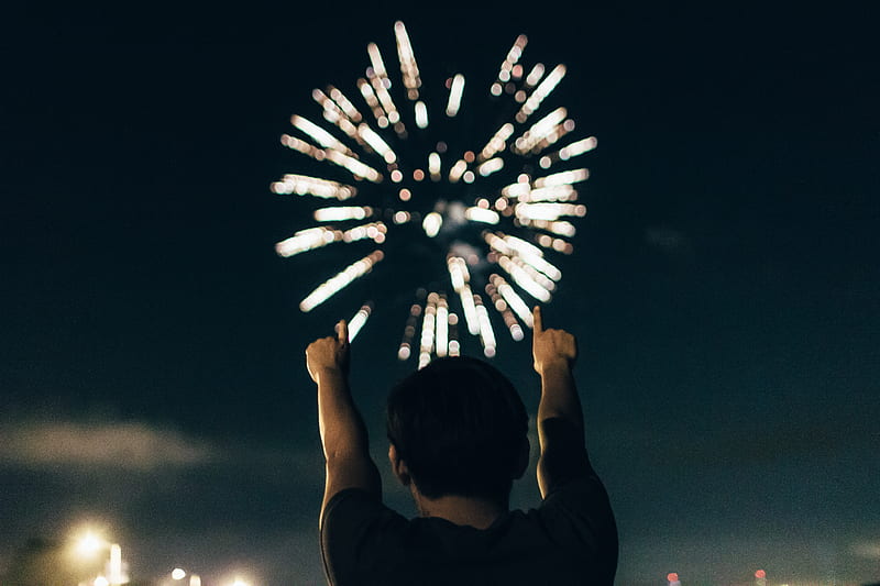 man in black shirt pointing towards brocade fireworks in the skies, HD wallpaper
