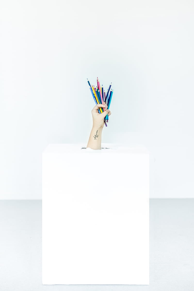 person's hand burst out of box holding assorted-color pens, HD phone wallpaper