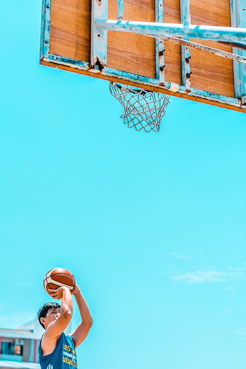 man holding basketball in front of basketball system during daytime, HD phone wallpaper