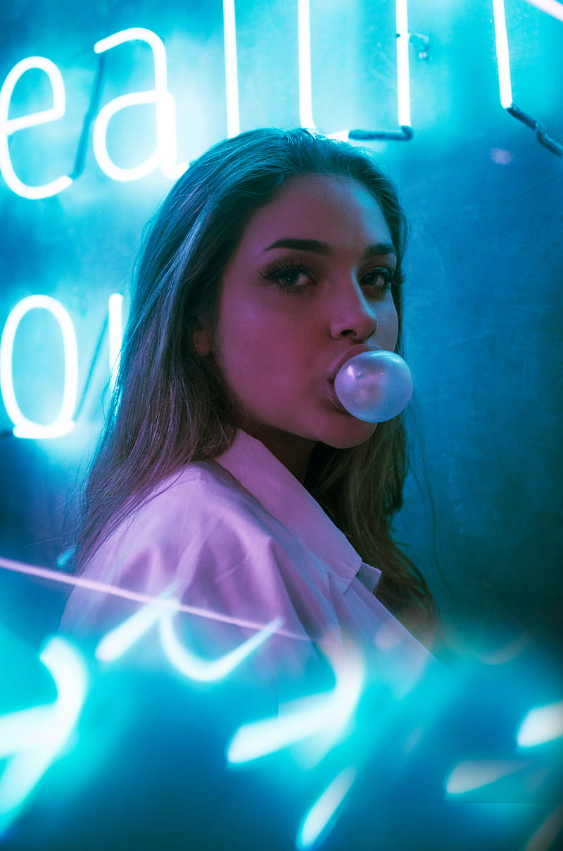selective focus of woman blowing gum standing in front of turned-on neon signage, HD phone wallpaper