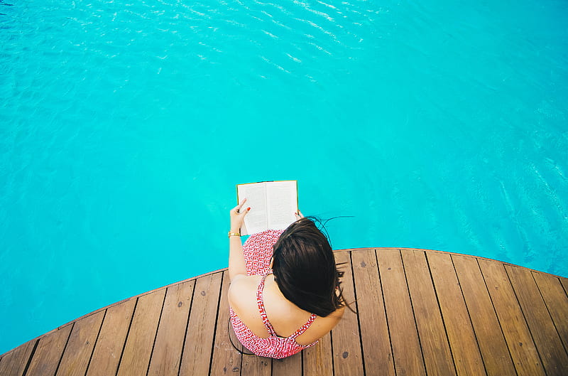 woman sitting on poolside dock while riding book, HD wallpaper