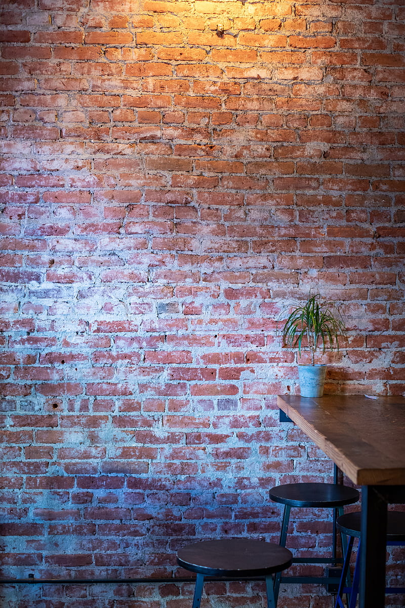 brown wooden dining table beside brown brick wall, HD phone wallpaper