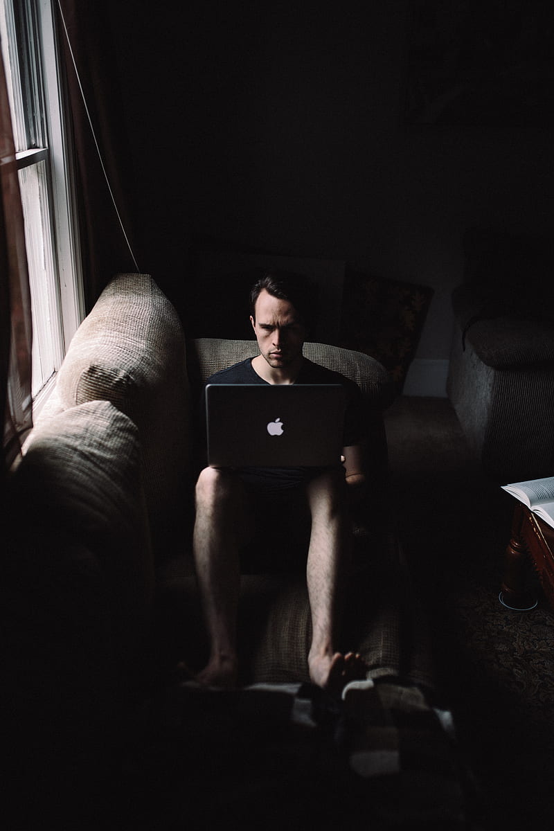 man seating on sofa using MacBook beside window, HD phone wallpaper