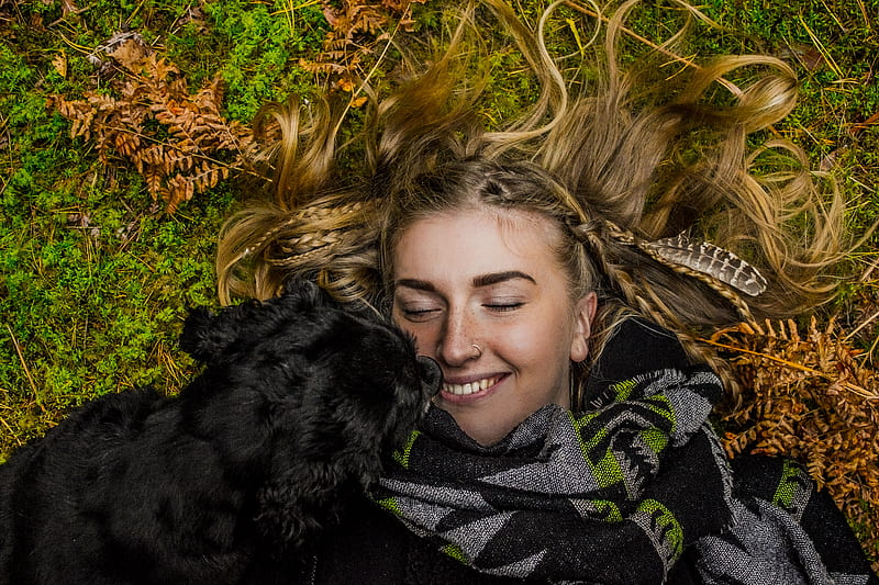 smiling woman lying on ground beside black dog at daytime, HD wallpaper