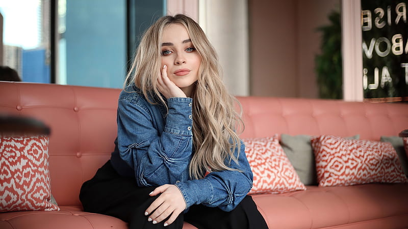 Sabrina Carpenter With Blue Shirt And Black Pant Is Sitting On The Couch Sabrina Carpenter, HD wallpaper