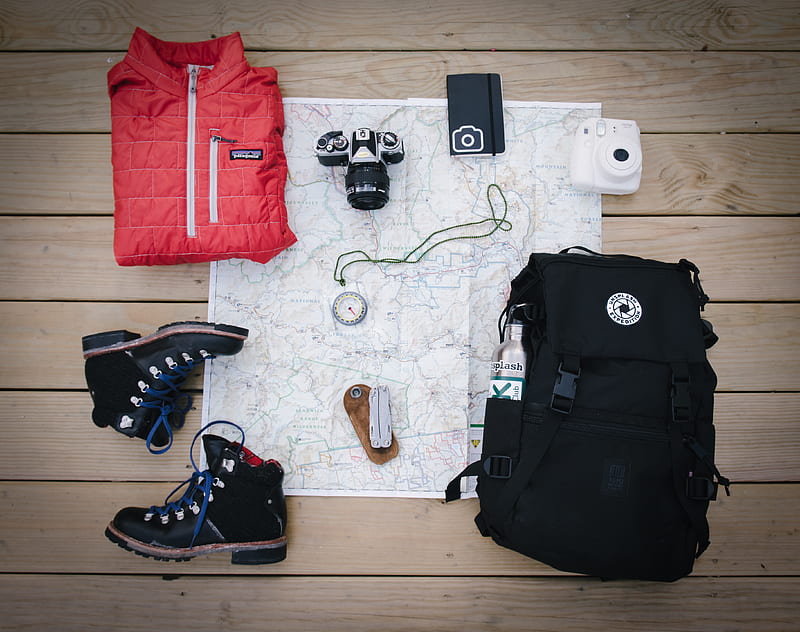 black hiking backpack near white Fujifilm instax mini camera near black leather boots, red half-zip jacket, gray pocket watch on white map, HD wallpaper