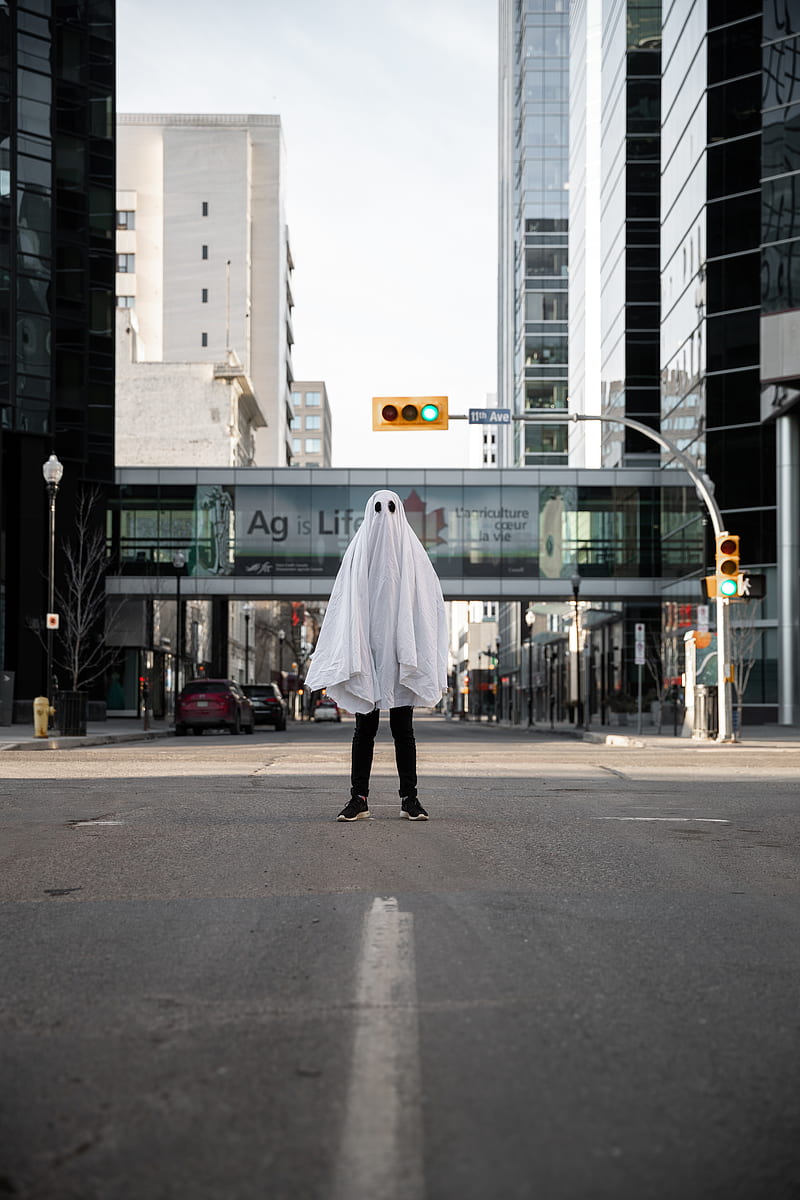 Person in white coat walking on sidewalk during daytime, HD phone