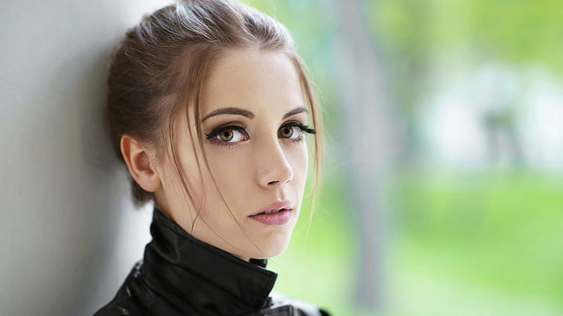 Girl Model Is Wearing Black Dress Leaning On White Wall Standing In