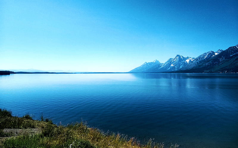 Side view of the Grand Tetons from across Jackson Lake in Wyoming, water, grass, sky, mountains, usa, HD wallpaper
