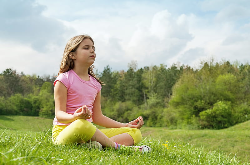 Little Cute Baby Girl Doing Yoga Exercise on the Grass at