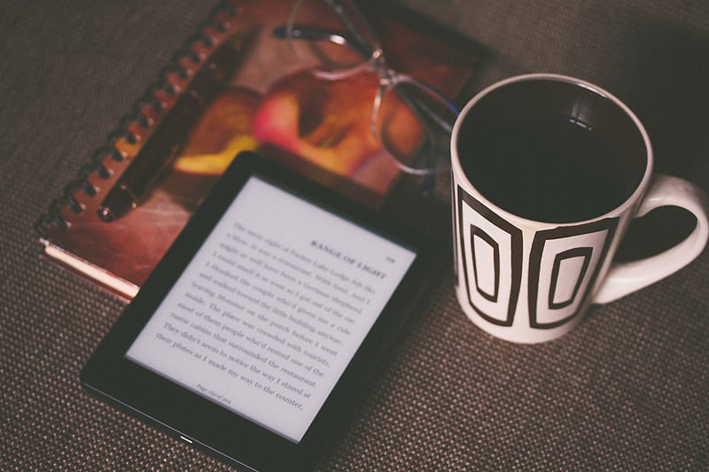 black E-book reader beside white and black mug, HD wallpaper