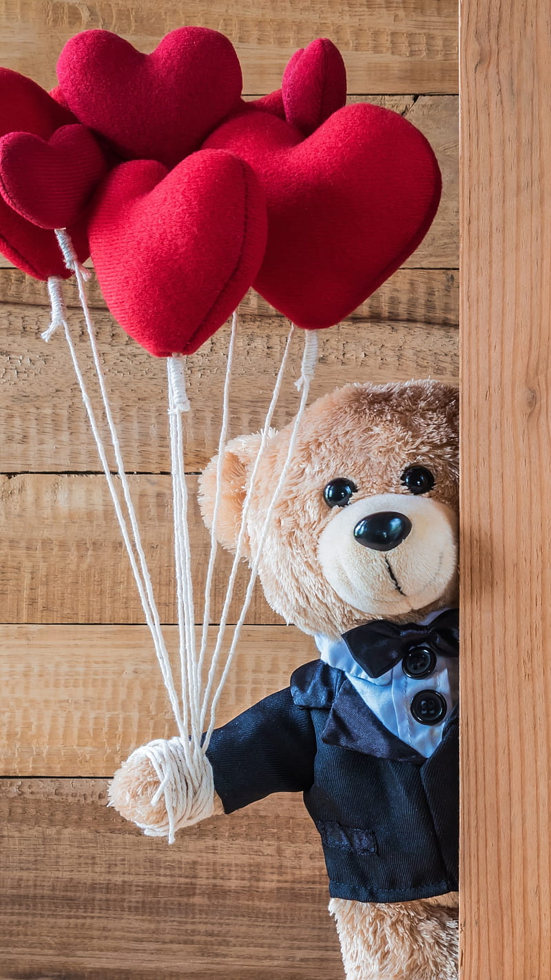 Cute and fluffy teddy bear with a gold bow tie for Valentines day with  hearts in the background 4K wallpaper download