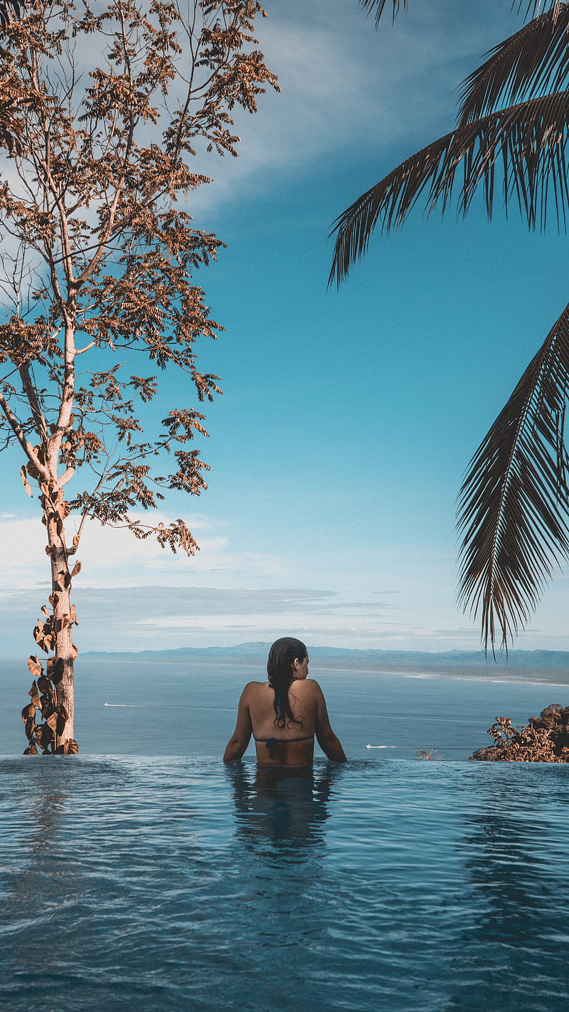 woman wearing black bikini tap swimming on body of water between trees, HD phone wallpaper