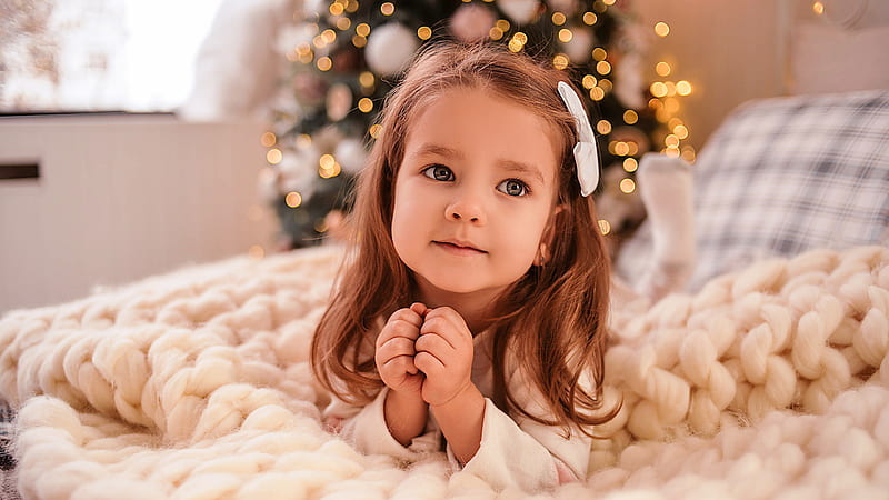 Cute Little Girl Is Lying Down On Bed In Bokeh Christmas Tree Background Cute, HD wallpaper