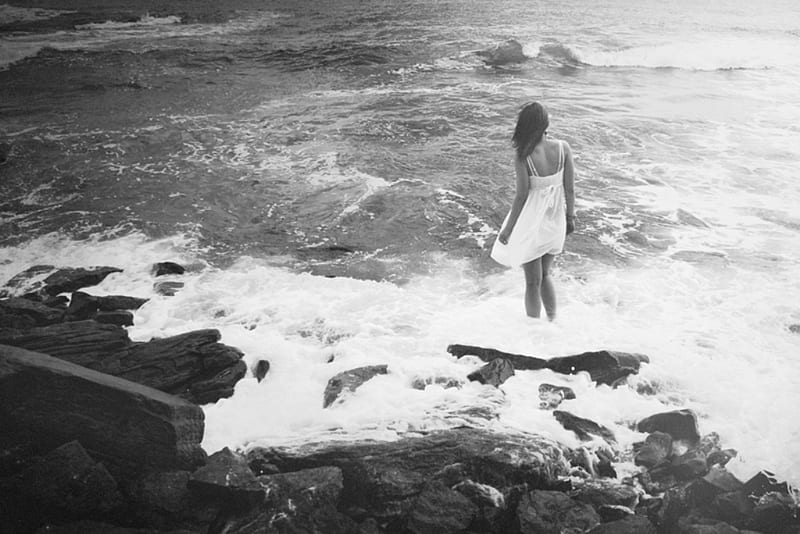 Alone in the sea, sadness, ocean, wind, black and white, dreams, lonely, waves, hopes, thinking about you, sea, stones, water, girl, waiting, love, white dress, HD wallpaper
