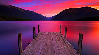 Jetty / Pier of Rocks with Man Fishing and Mountain Backdrop