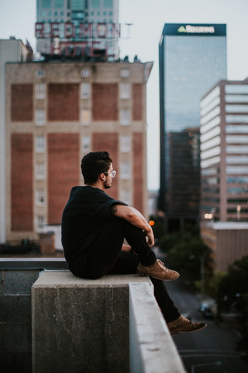 man sitting on white concrete building during daytime, HD phone wallpaper