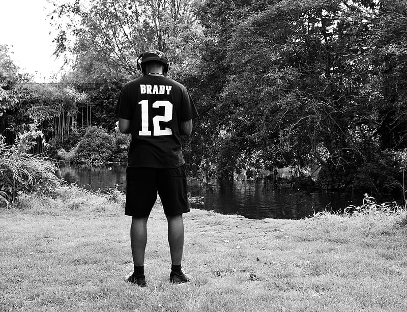 grayscale of man in black and white jersey shirt and shorts standing on grass field, HD wallpaper