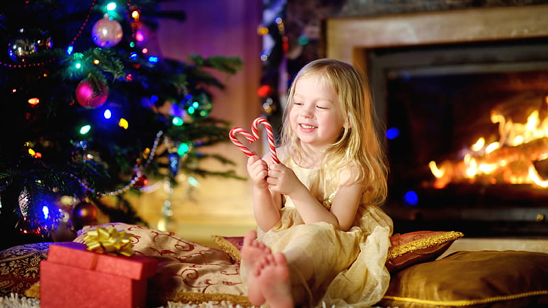Smiley Cute Little Girl Is Having Candy Cane In Hands Sitting On Bed ...