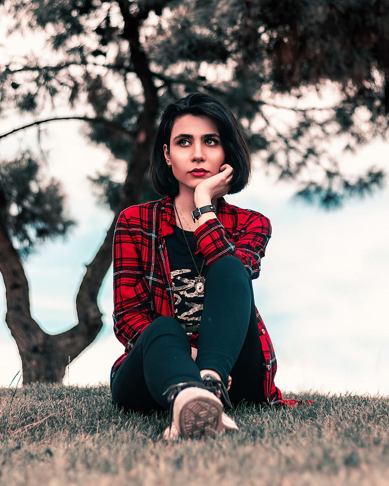woman in red and black plaid dress shirt and black pants sitting on grass field, HD phone wallpaper
