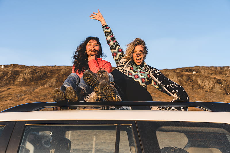 two woman sitting on top of white vehicle under blue sky during daytime, HD wallpaper