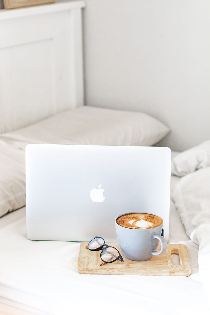 macbook air beside white ceramic mug on white bed, HD phone wallpaper