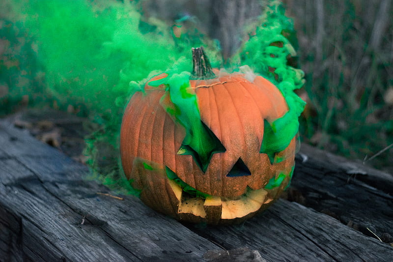 Jack-o'-lantern releasing green smoke on grey wooden board, HD wallpaper