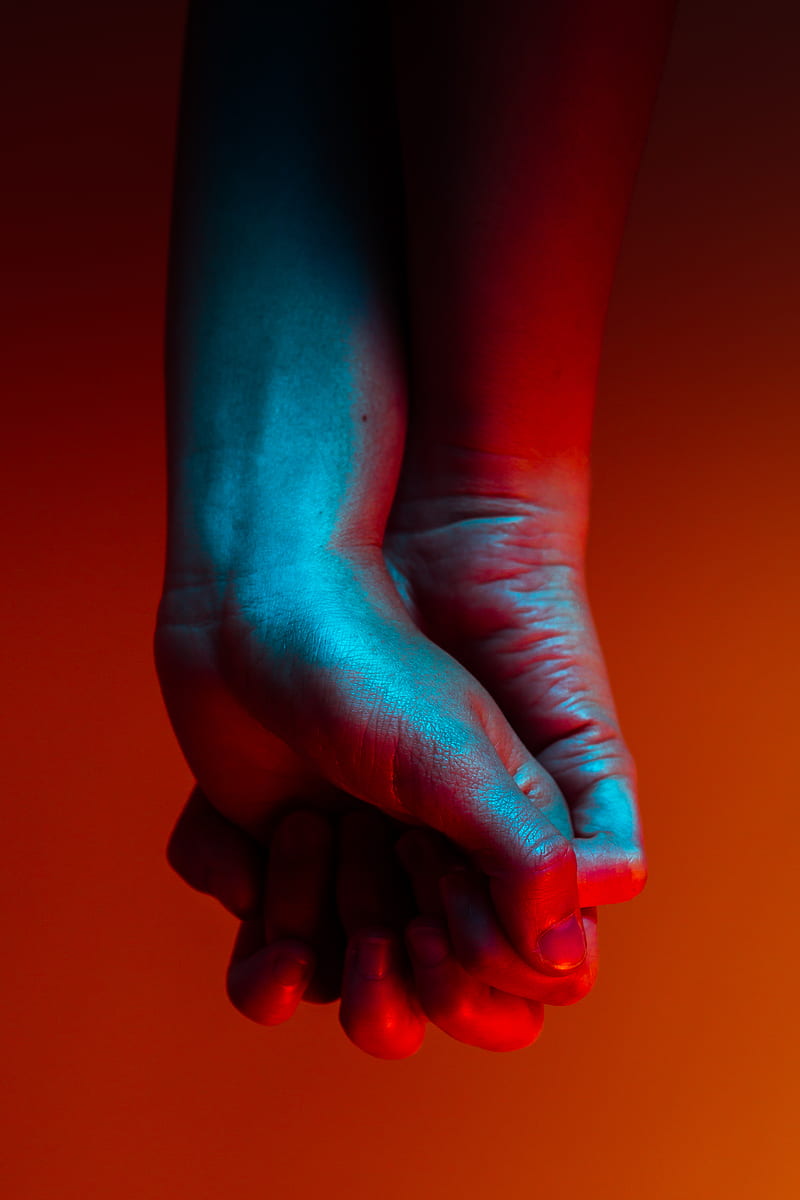two person holding hands near orange background, HD phone wallpaper