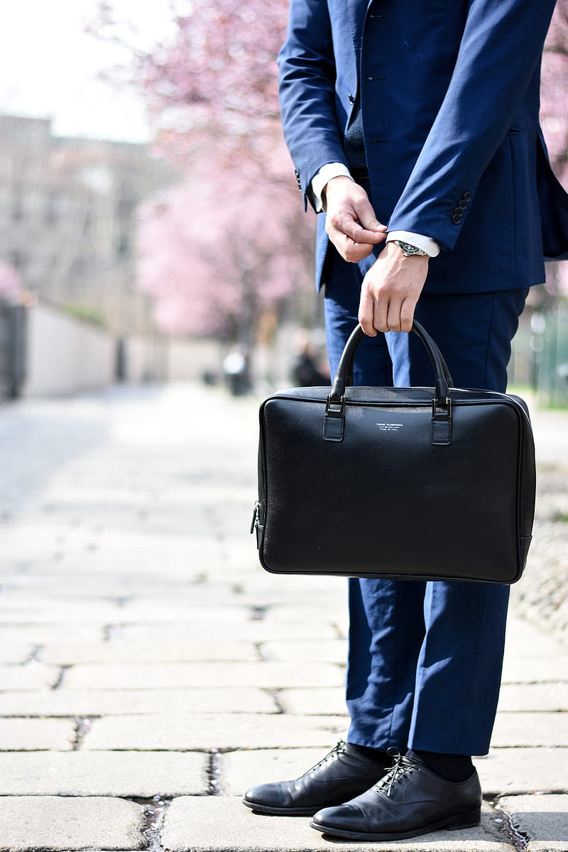 man in blue suit standing on street side while holding bag during daytime, HD phone wallpaper