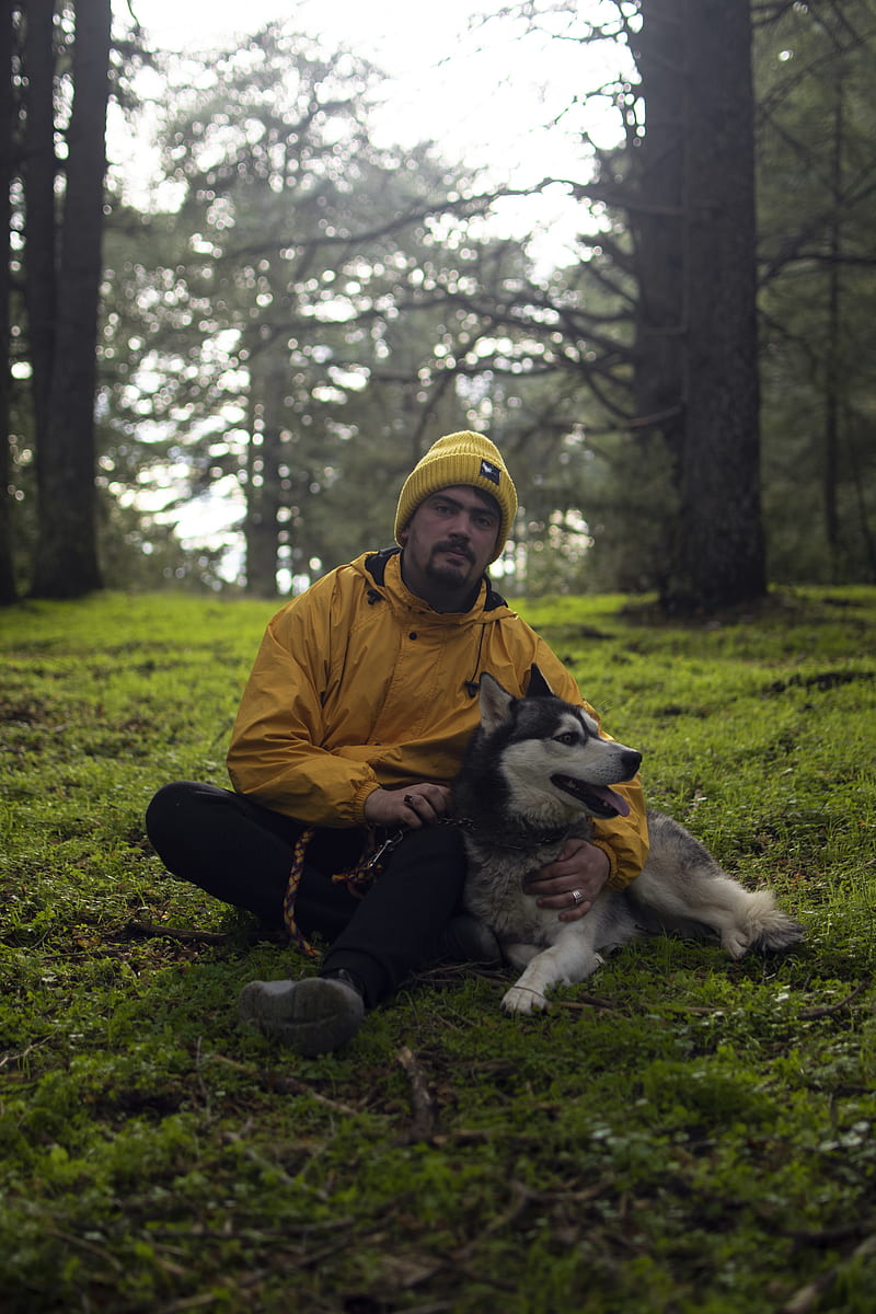 Man in Brown Jacket Sitting on Ground With Black and White Siberian Husky, HD phone wallpaper