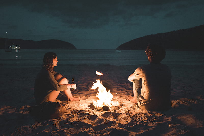 man and woman with bone fire sitting on seashore, HD wallpaper
