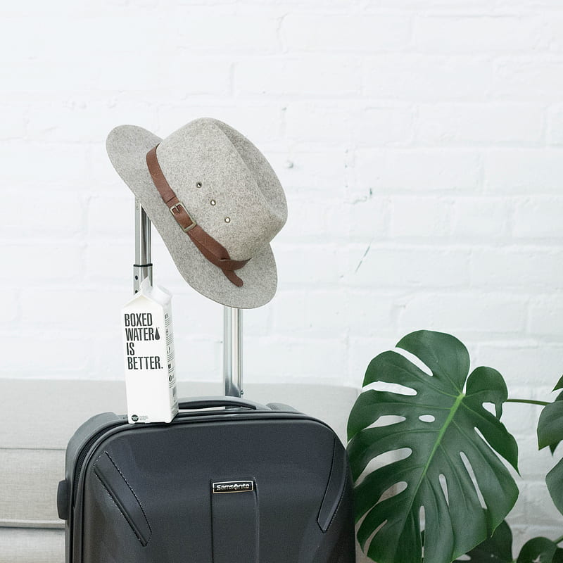 A hat and Boxed Water carton sit on a suitcase, HD phone wallpaper