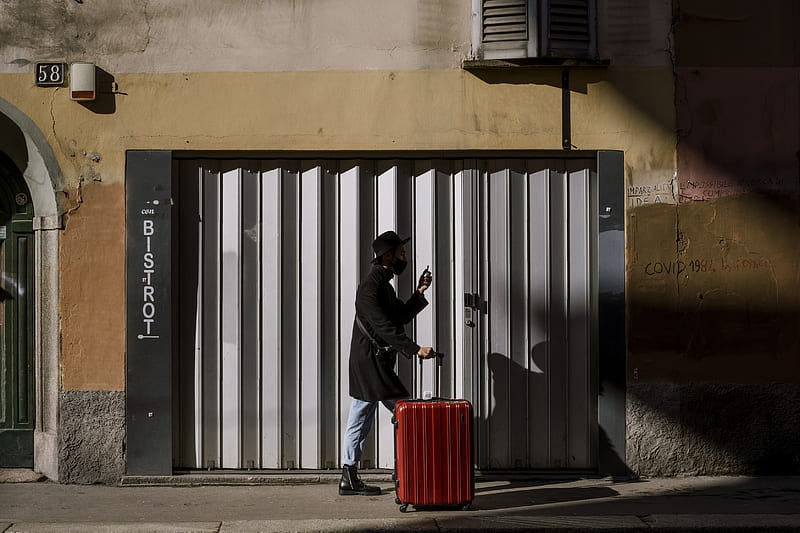 man in black jacket and blue denim jeans standing beside red trash bin, HD wallpaper