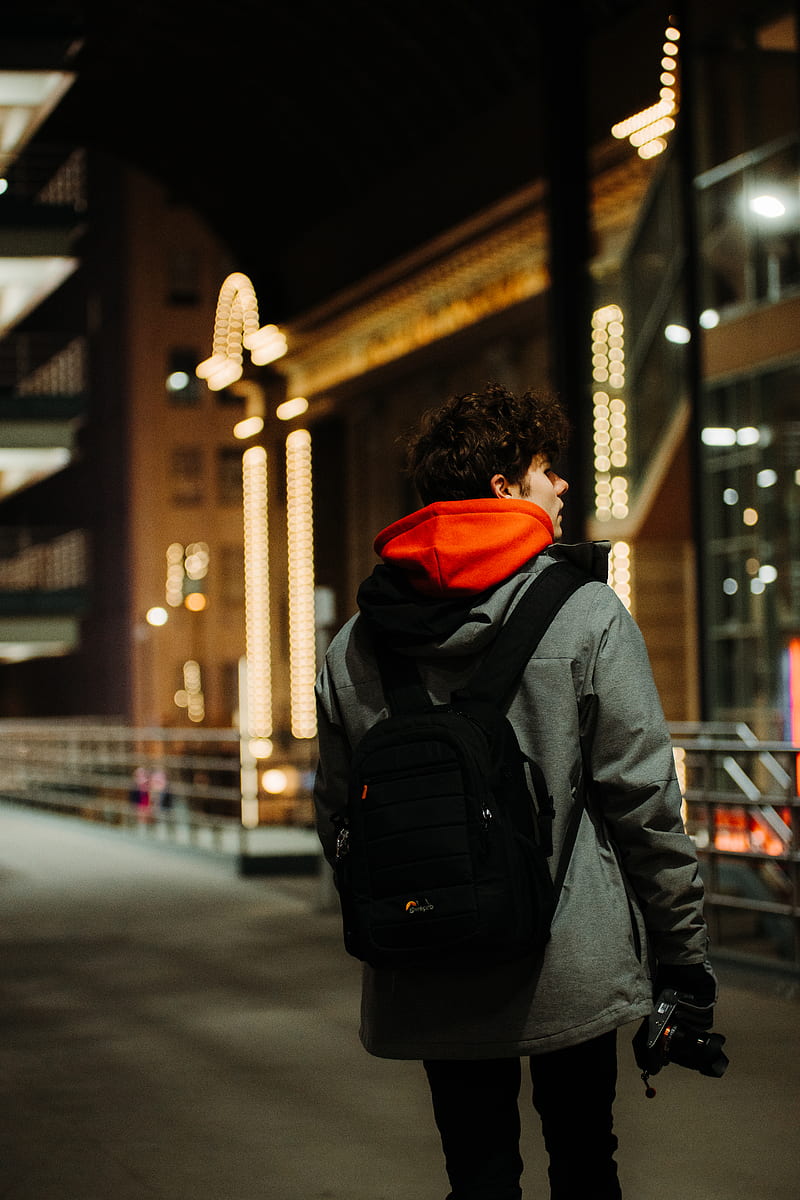 person in black and orange hoodie and black backpack walking on sidewalk during daytime, HD phone wallpaper