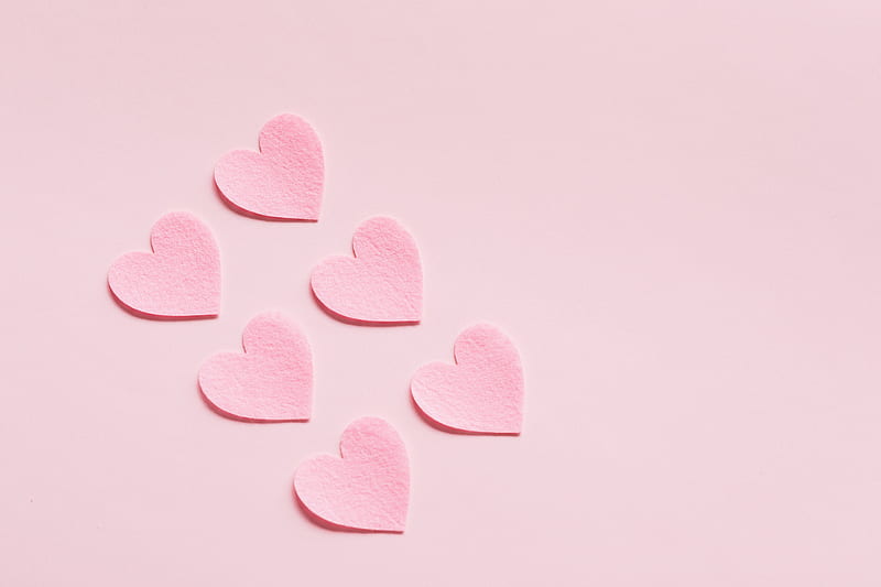From above of composition made with heart shaped papers cutout of rough uneven pink cardboard placed diagonally on light pink background, HD wallpaper