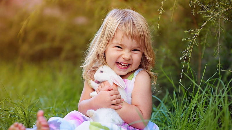 Smiley Cute Baby Girl Is Sitting On Green Grass Holding Rabbit Wearing White Dress In Green Blur Background Cute, HD wallpaper