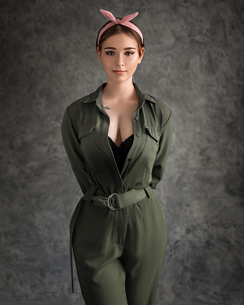 Evgeny Sibiraev, women, brunette, hairband, makeup, eyeliner, looking at viewer, smirk, green clothing, tattoo, simple background, overalls, cleavage, HD phone wallpaper