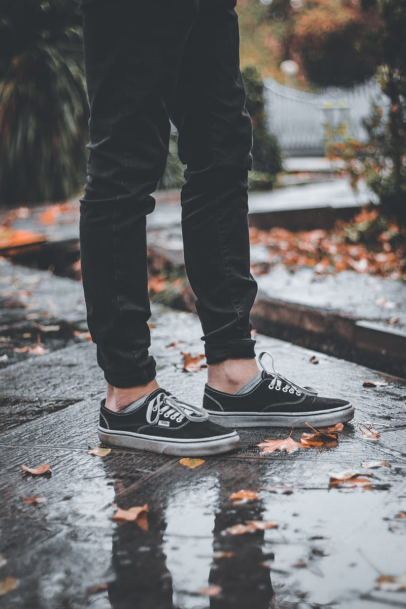 Persona en pantalones negros y zapatillas Nike en blanco y de sobre el pavimento de hormigón gris, Fondo de pantalla de teléfono HD | Peakpx